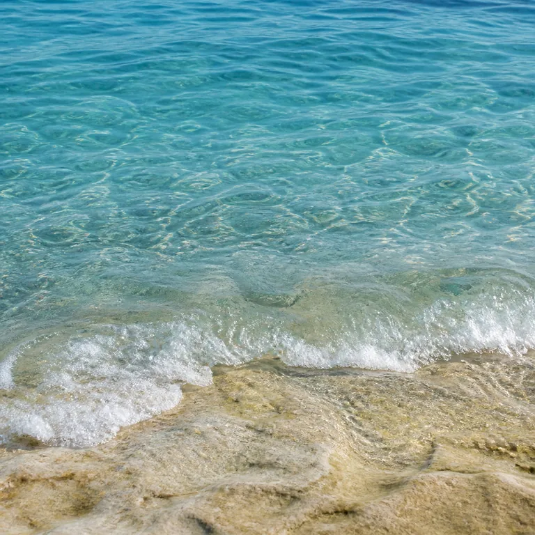 ภาพประกอบคำศัพท์จีน 海水 น้ำทะเลใสซัดเหนือชั้นหินริมฝั่ง